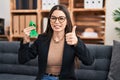 Young woman holding support green ribbon smiling happy and positive, thumb up doing excellent and approval sign