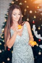 Young woman holding sweet mandarin, orange mood. Girl in a dress is going to eat tangerines Royalty Free Stock Photo