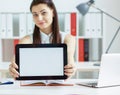 Young business woman holding tablet with copy space for text or picture. Stylish modern office workplace on a background