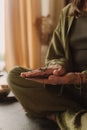 Young Woman holding Tarot cards and sitting in lotus pose on yoga mat, relaxed with closed eyes. Mindful meditation concept.