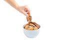 Young woman holding tasty chocolate chip cookie over bowl on white background Royalty Free Stock Photo