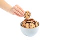 Young woman holding tasty chocolate chip cookie over bowl on white background Royalty Free Stock Photo