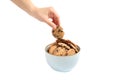 Young woman holding tasty chocolate chip cookie over bowl on white background Royalty Free Stock Photo