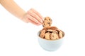 Young woman holding tasty chocolate chip cookie over bowl on white backgroun Royalty Free Stock Photo