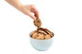 Young woman holding tasty chocolate chip cookie over bowl on white background Royalty Free Stock Photo