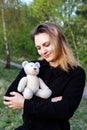 Portrait of young woman holding a teddy bear outdoors in nature Royalty Free Stock Photo