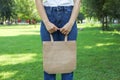 Young woman holding tote bag against greenery background Royalty Free Stock Photo