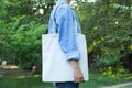 Young woman holding tote bag against greenery Royalty Free Stock Photo