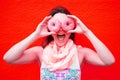 Young woman holding two pink donuts to her eyes Royalty Free Stock Photo