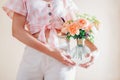 Young woman holding vase with bouquet of fresh flowers. Floral arrangement with orange roses Lady of Shallott Royalty Free Stock Photo