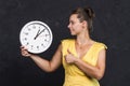 A young woman is holding a watch. Time concept. A girl with a clock in her hands. Keep track of time