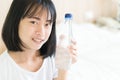 Young woman holding water bottle with happy face and smiling, h Royalty Free Stock Photo