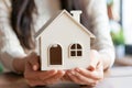 Young Woman Holding a White Model House in Her Hands Indoors Royalty Free Stock Photo