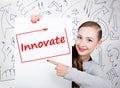 Young woman holding whiteboard with writing word: innovate. Technology, internet, business and marketing.