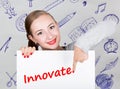 Young woman holding whiteboard with writing word: innovate. Technology, internet, business and marketing. Royalty Free Stock Photo