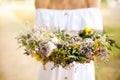 Young woman holding wreath made of beautiful flowers outdoors on sunny day, closeup Royalty Free Stock Photo