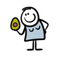A young woman holds an avocado in her hand and thinks about a healthy lifestyle.