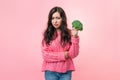 A young woman holds broccoli in her hand. The girl was tired of dieting. Diet food concept