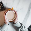 Young woman holds a cup of delicious hot americano with milk while sitting in an vintage coffee shop. Coffee gourmet. Good morning Royalty Free Stock Photo