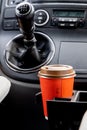 Young woman holds disposable cup of coffee in the car, to keep concentrated while driving Royalty Free Stock Photo