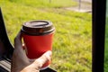 Young woman holds disposable cup of coffee in the car, to keep concentrated while driving Royalty Free Stock Photo