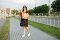 A young woman holds a grocery bag and a glass of coffee. The concept of shopping, eco shopping, lifestyle