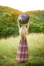 Young woman holds Handpan musical instrument above her head. Sunset meditation