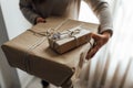 Young woman holds in hands stacked Christmas gift boxes in craft paper with juniper. Christmas presents concept Royalty Free Stock Photo