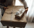 Young woman holds in hands stacked Christmas gift boxes in craft paper with juniper. Christmas presents concept Royalty Free Stock Photo