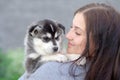 Young women holds her best friend little pet puppy of husky in her arms. love for dogs Royalty Free Stock Photo