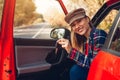 Young woman holds keys of new car. Happy driver looking at camera sitting in auto. Happy buyer purchased red autimobile Royalty Free Stock Photo