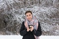 Young woman holds mug of tea in  hands, cold snowy forest. Winter picnic, weekend concept Royalty Free Stock Photo