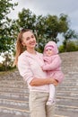 Young woman holds one-year-old baby girl in her arms Royalty Free Stock Photo