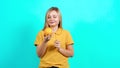 The young woman holds an orange in her hands and promotes a healthy lifestyle.