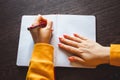 Young woman holds a pen in her left hand and writes note in blank notebook. International Left-Handers Day