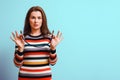 Young woman holds spdif digital audio coaxial cable in her hands and is confused. Studio shot