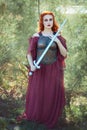 Young woman holds a sword in her hand. Royalty Free Stock Photo