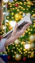 Young woman holds up hardcover book to read an article to learn and understand article is in book on blurred background of night