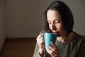 Young woman at home drinking coffee in a blue mug Royalty Free Stock Photo