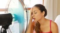 Young woman at home in hot summer day in front of the working fan suffering from summer heat Royalty Free Stock Photo