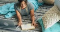 Young woman at home laying on the floor studying with laptop computer and book - happy lifestyle female people relax Royalty Free Stock Photo