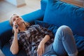 Young woman at home in the living room lying on coach phone call Royalty Free Stock Photo