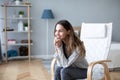 Young woman at home sitting on modern chair relaxing in her living room Royalty Free Stock Photo