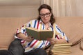 Young woman at home sitting on sofa in front of window relaxing in her living room Royalty Free Stock Photo