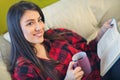 Young woman at home sitting on sofa relaxing in her living room Royalty Free Stock Photo