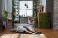 Young woman in homeware practicing balance yoga pose on carpet in her comfy bedroom.