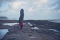 Young woman in hooded coat walking on beach Royalty Free Stock Photo