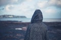 Young woman in hooded coat walking on beach Royalty Free Stock Photo