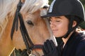 Young woman in horse riding suit and her beautiful pet outdoors on sunny day, closeup Royalty Free Stock Photo