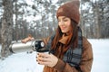 Young woman with hot drink thermos at winter forest Royalty Free Stock Photo